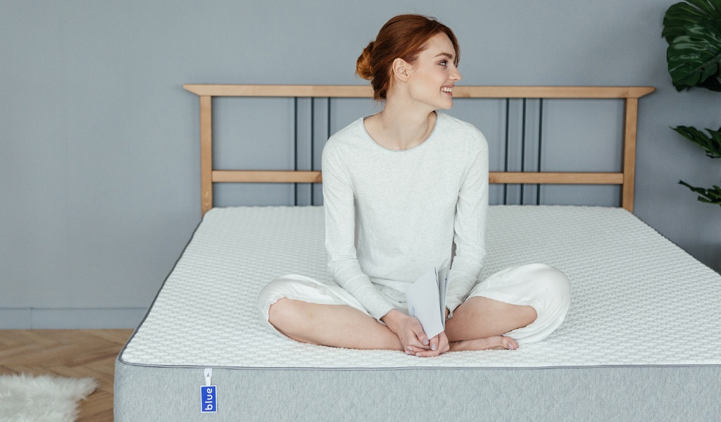 Женщина сидит на кровати Blue Sleep