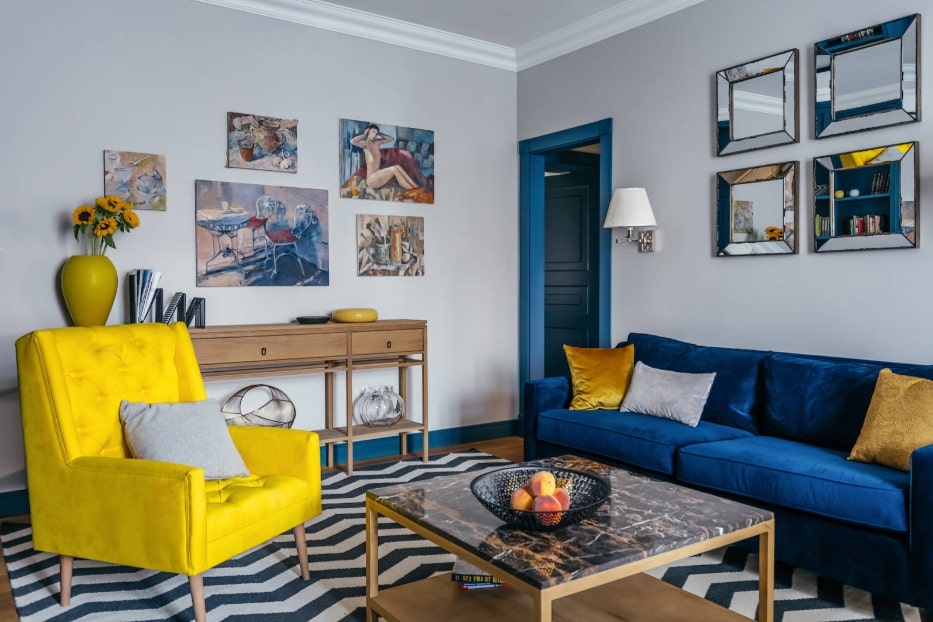 Желтое кресло напротив синего дивана в гостиной